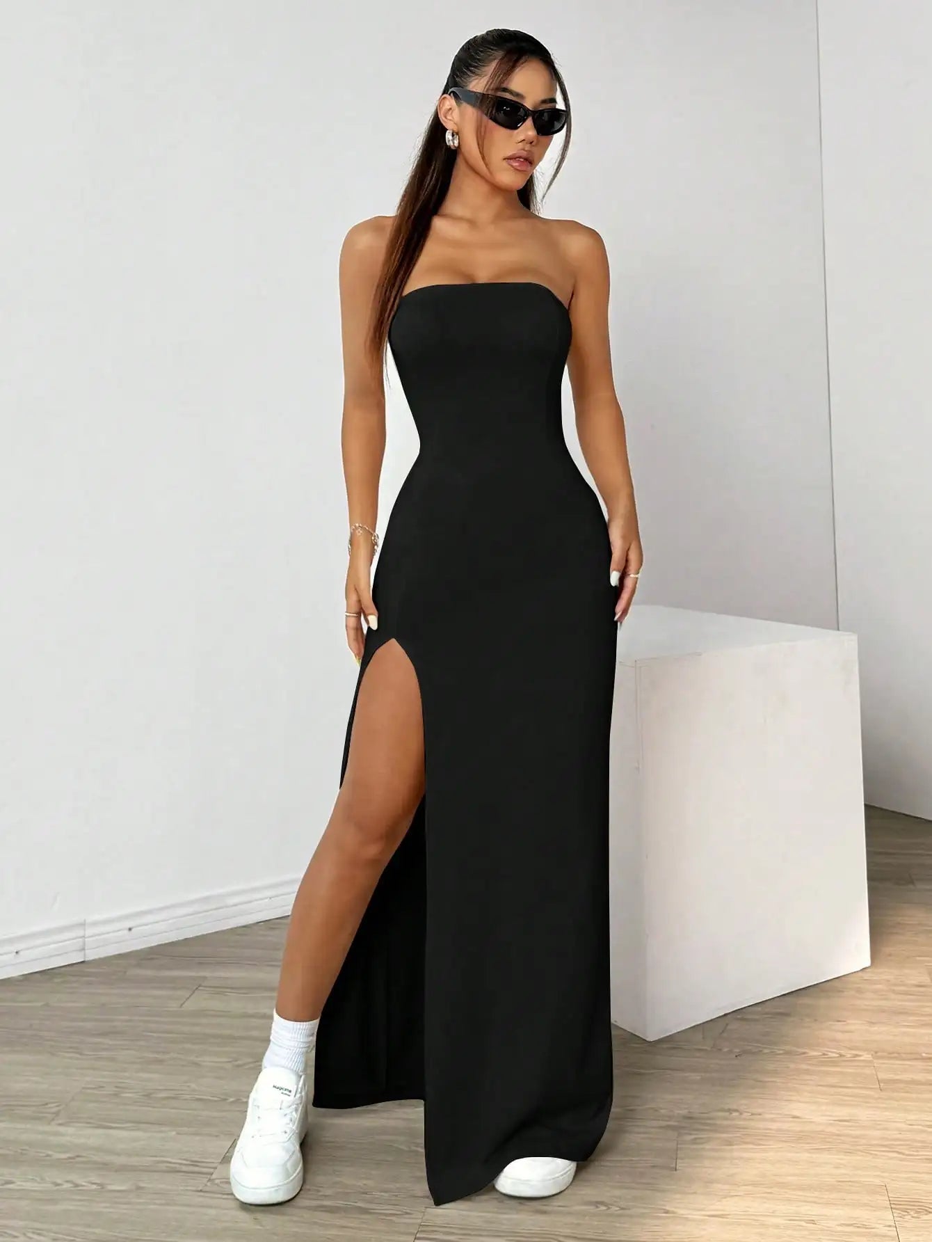 Elegant long strapless dress, with a side slit, in a simple solid color.
